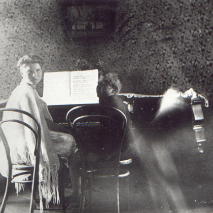 Melānija un mazais brālis Verners pie klavierēm - 20.gs. 20.gadi"Sermuļos"